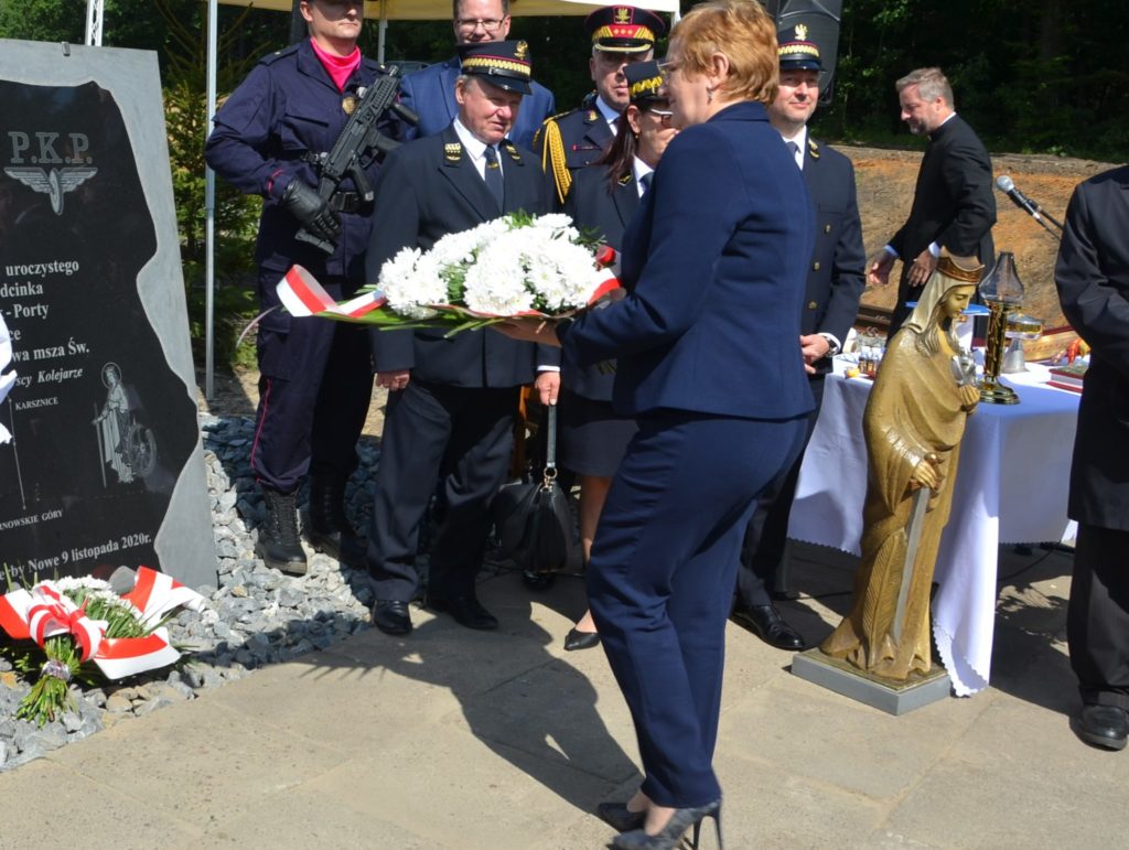 Starosta składa kwiaty pod pamiątkową tablicą