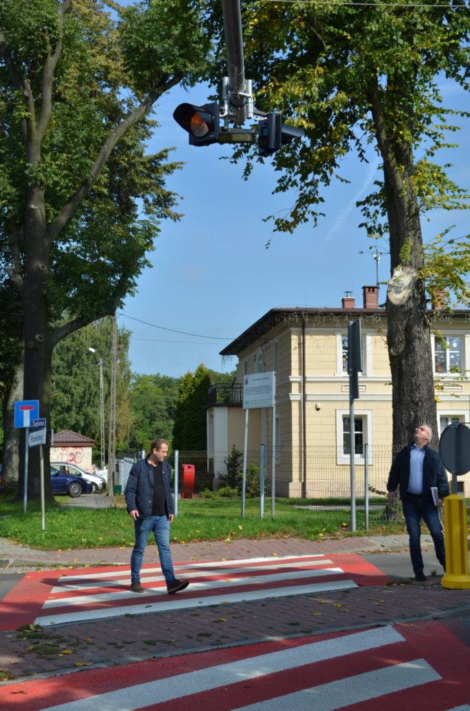 dwóch mężczyzn przechodzi przez przejscie dla pieszych w MIasteczku  Sląskim ulica Rubinowa