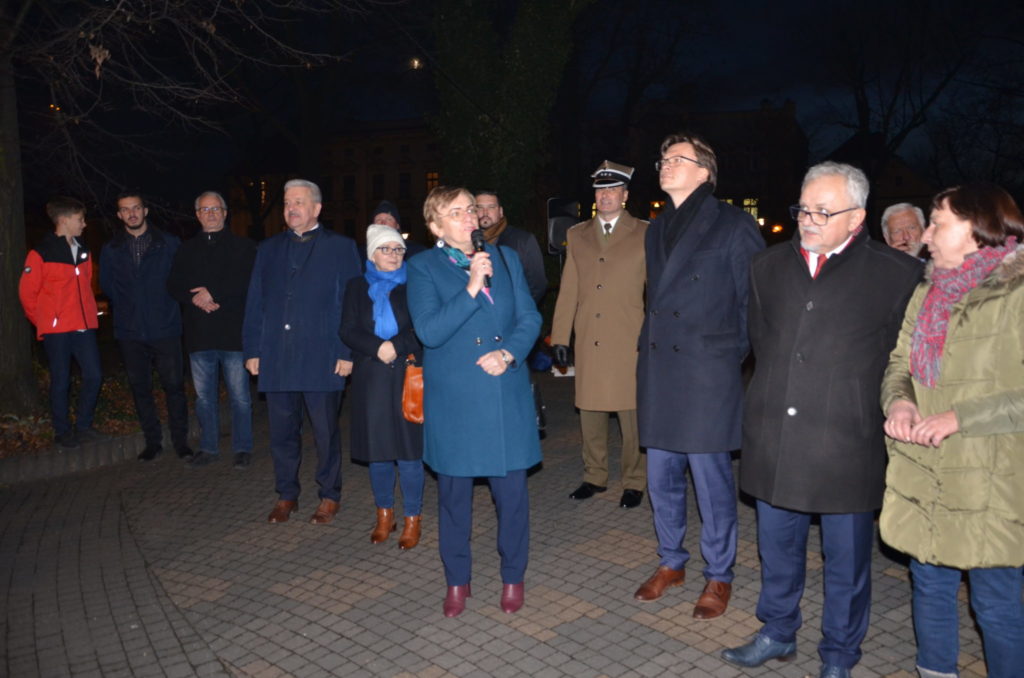 Starosta Krystyna Kosmala obok burmistrz Arkadiusz Czech oraz kilka osób, w tym członkowie zarządu powiatu, wojskowi,