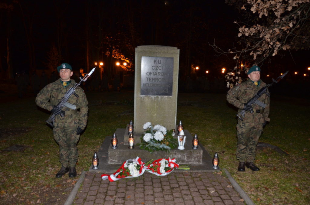 pomnik na cmentarzyu wojskowym obok warta honorwa dwóch żołnierzy