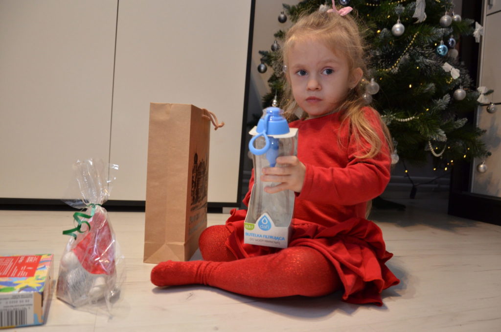 mała dziweczynka trzyma butelke do wody - bidon