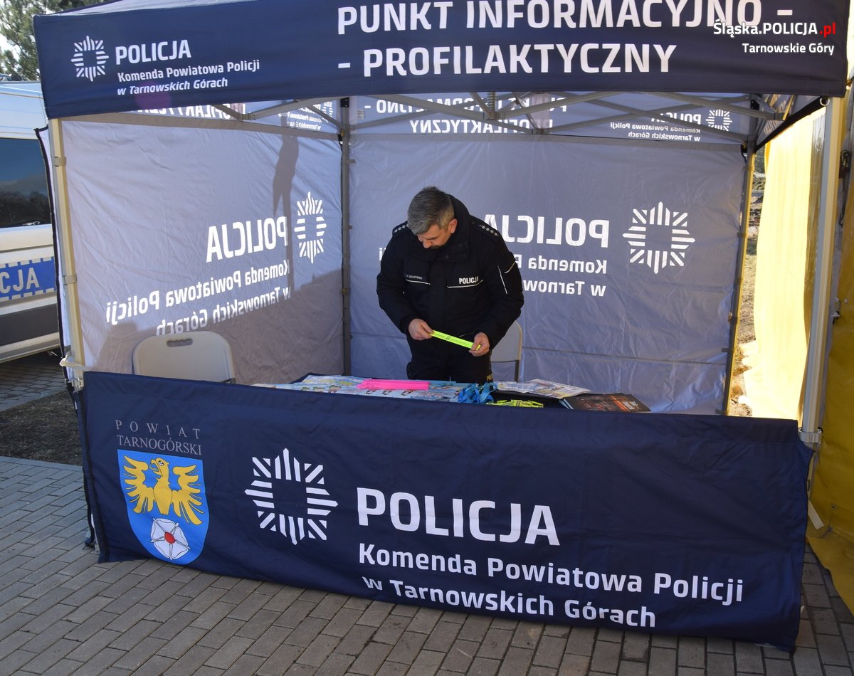 policjant podczas akcji profilaktycznej w namiocie z napisami policja