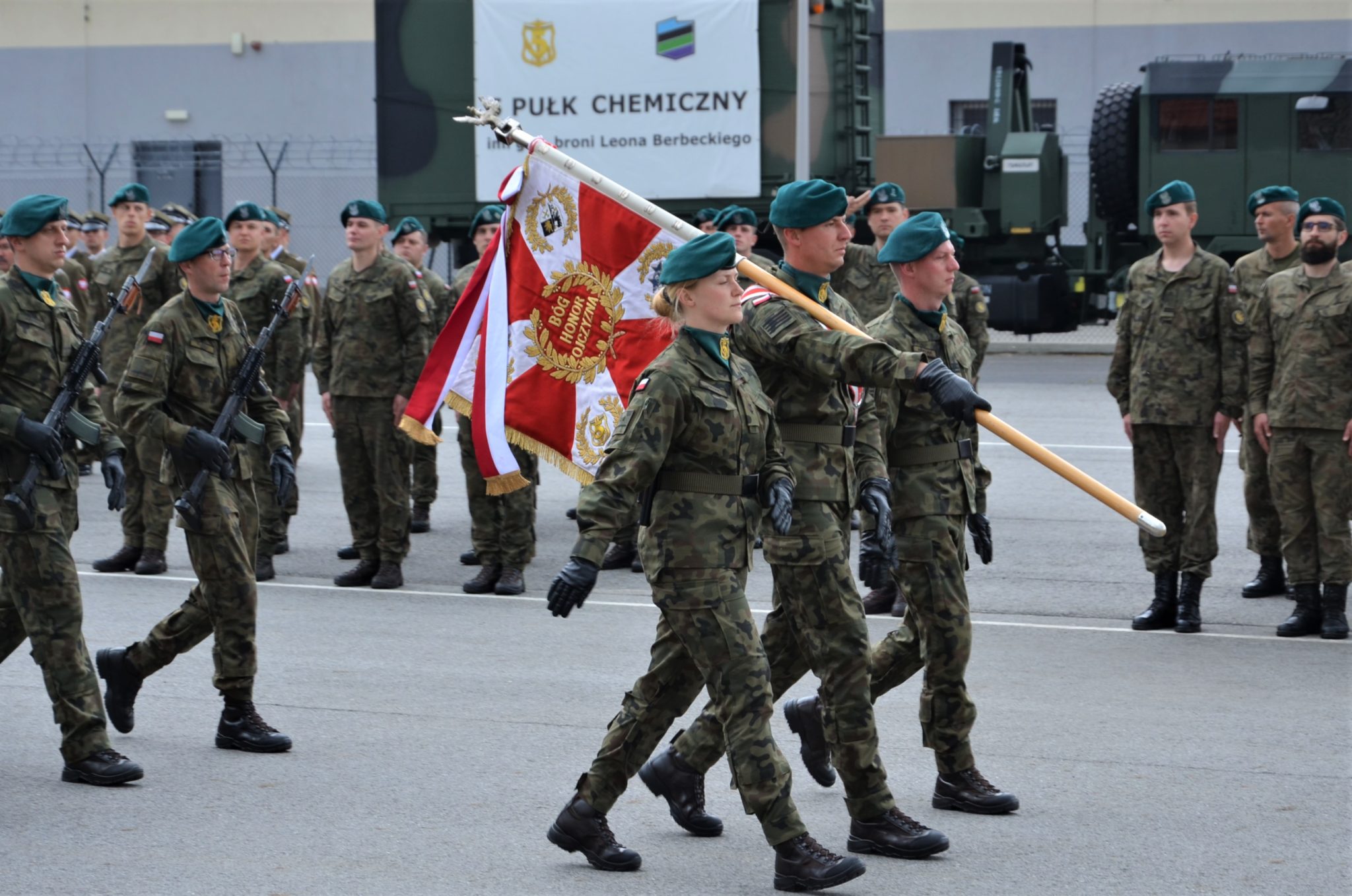 grupa żołnierzy, na pierwszym planie żołnierze niosący sztandar