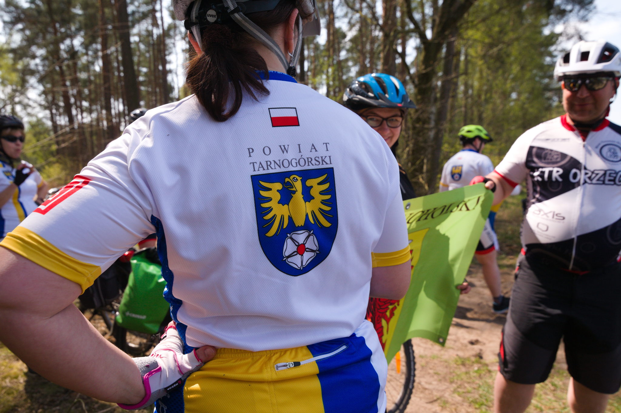 kobieta na rowerze w koszulce z logo powiatu