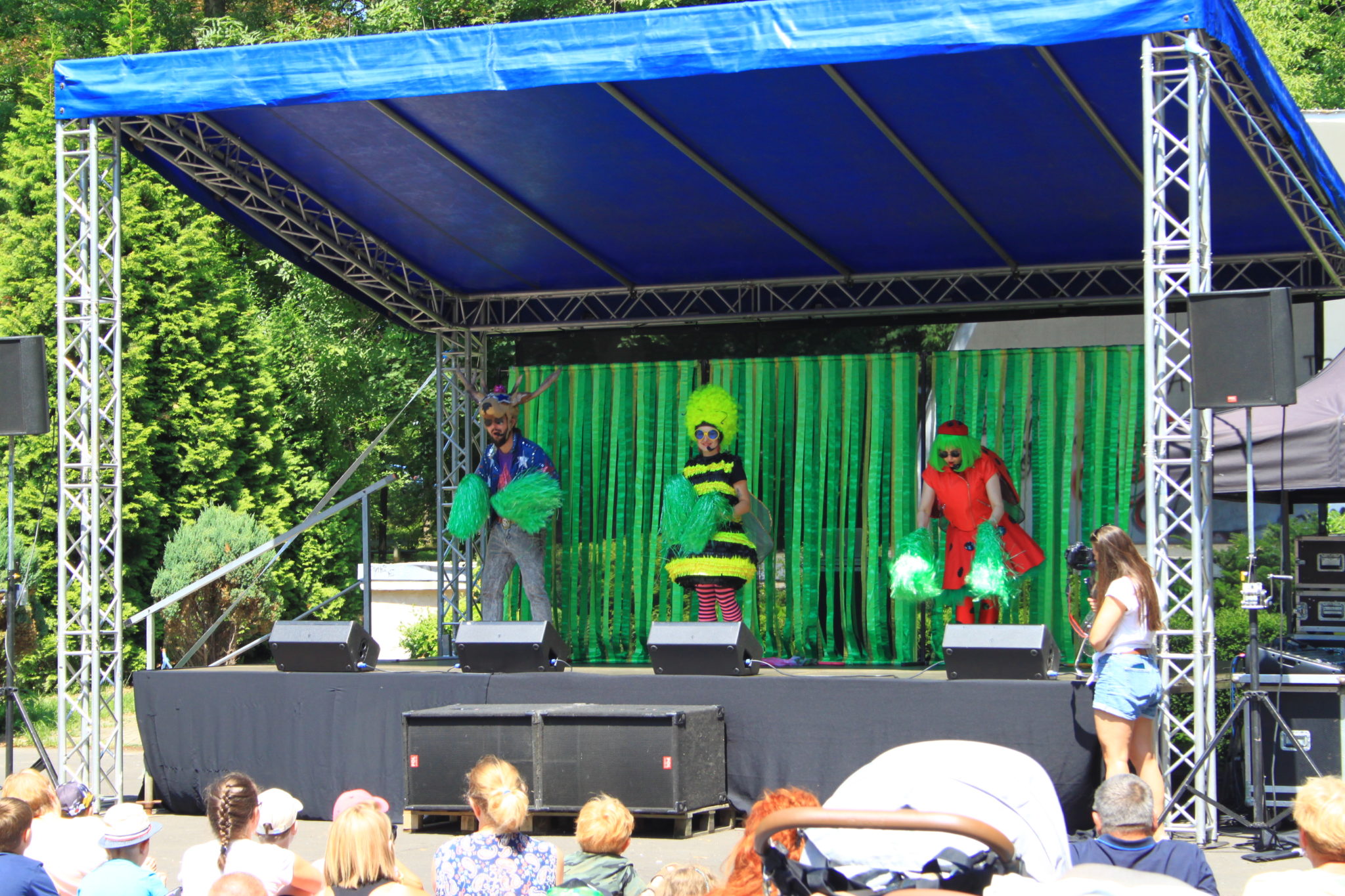trzy osoby w kostiumach stoją na scenie
