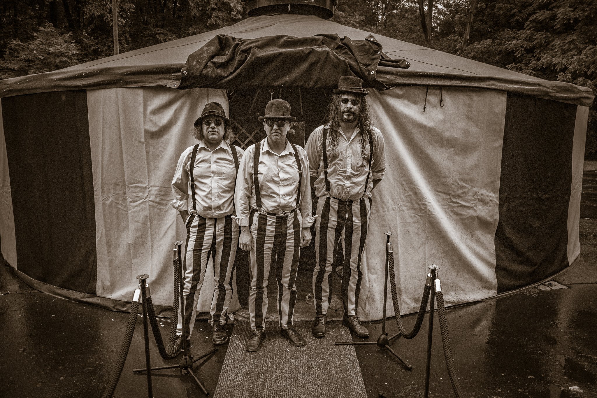 Trzy osoby stojące przed dużym namiotem