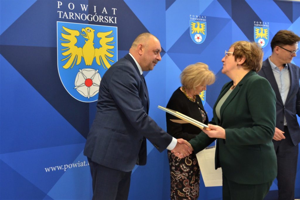 Starosta wręcza dokument mężczyźnie i podają sobie ręce.