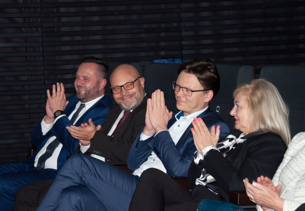 Grupa osób siedzących obok siebie.