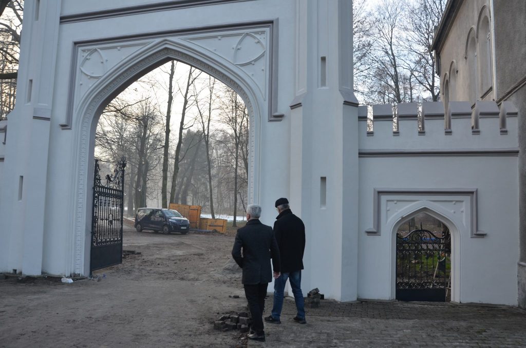 Sebastian Nowak i Krzysztof Łoziński oglądają wyremontowaną zabytkową bramę i ogrodzenie 