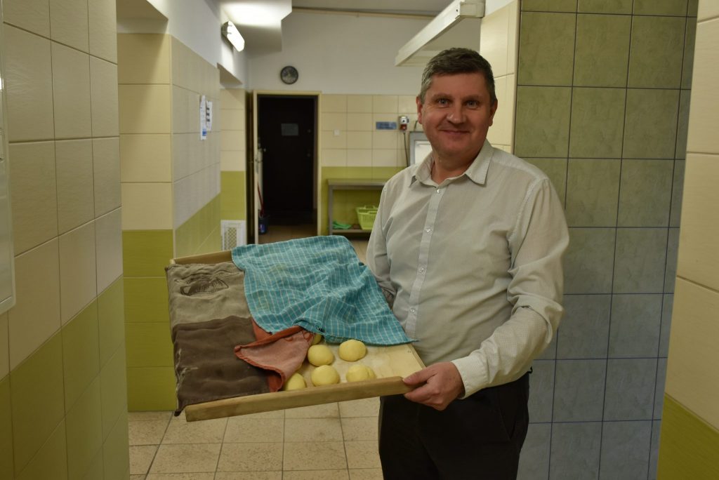Dyrektor szkoły Tomasz Respondek z tacą pączków.