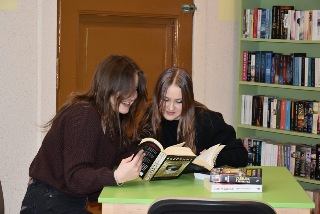 Dwie dziewczyny siedzące przy stoliku w bibliotece