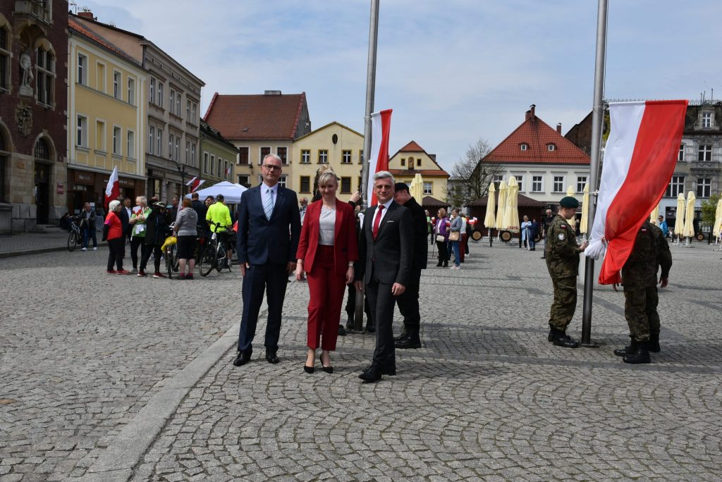 Grupa osób zgromadzona na tarnogórskim rynku. Po prawej stronie flagi polski.