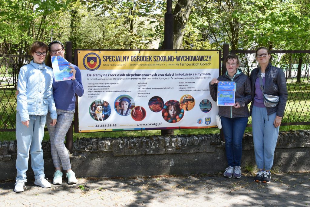 Grupa młodzieży przy banerze z napisem Specjalny Ośrodek Szkolno- Wychowawczy.