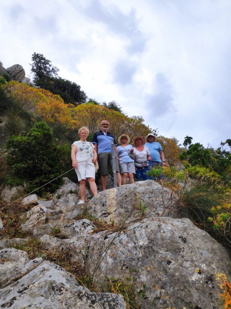Grupa osób stojących na skałach.