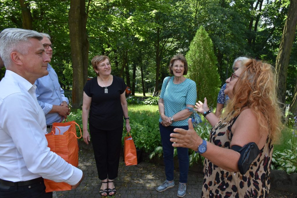 kilkanaście osób podczas rozmowy w parku