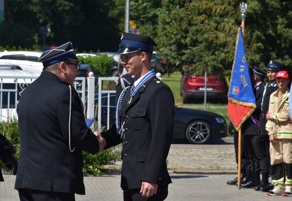 Mężczyźni w mundurach podają sobie dłonie. 