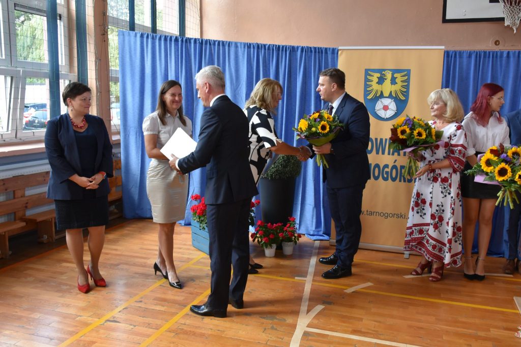 uroczysta akademia w sali szkolnej podczas wręczania kwiatów kobietom