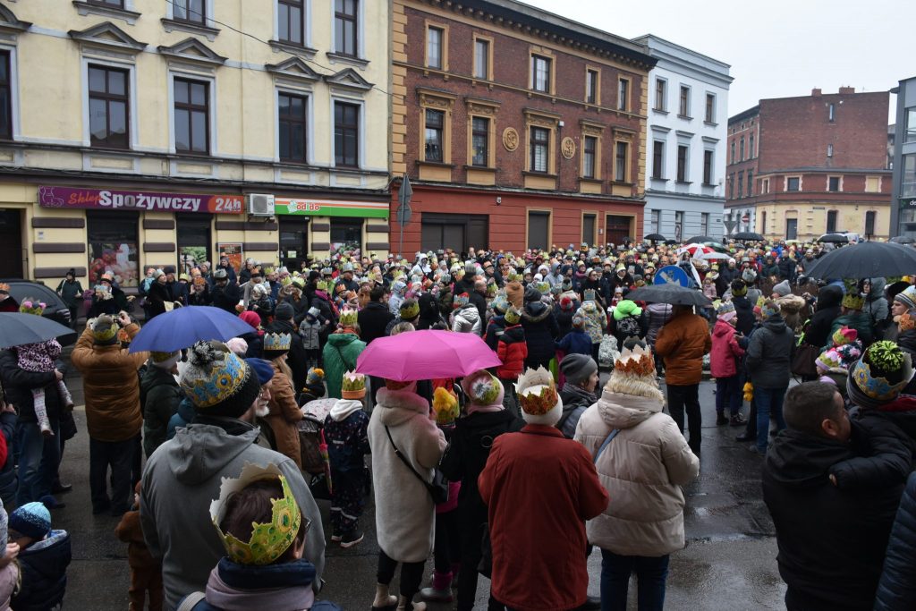 Duża grupa osób zgromadzona na miejskim placu. W tle wysoka zabudowa.