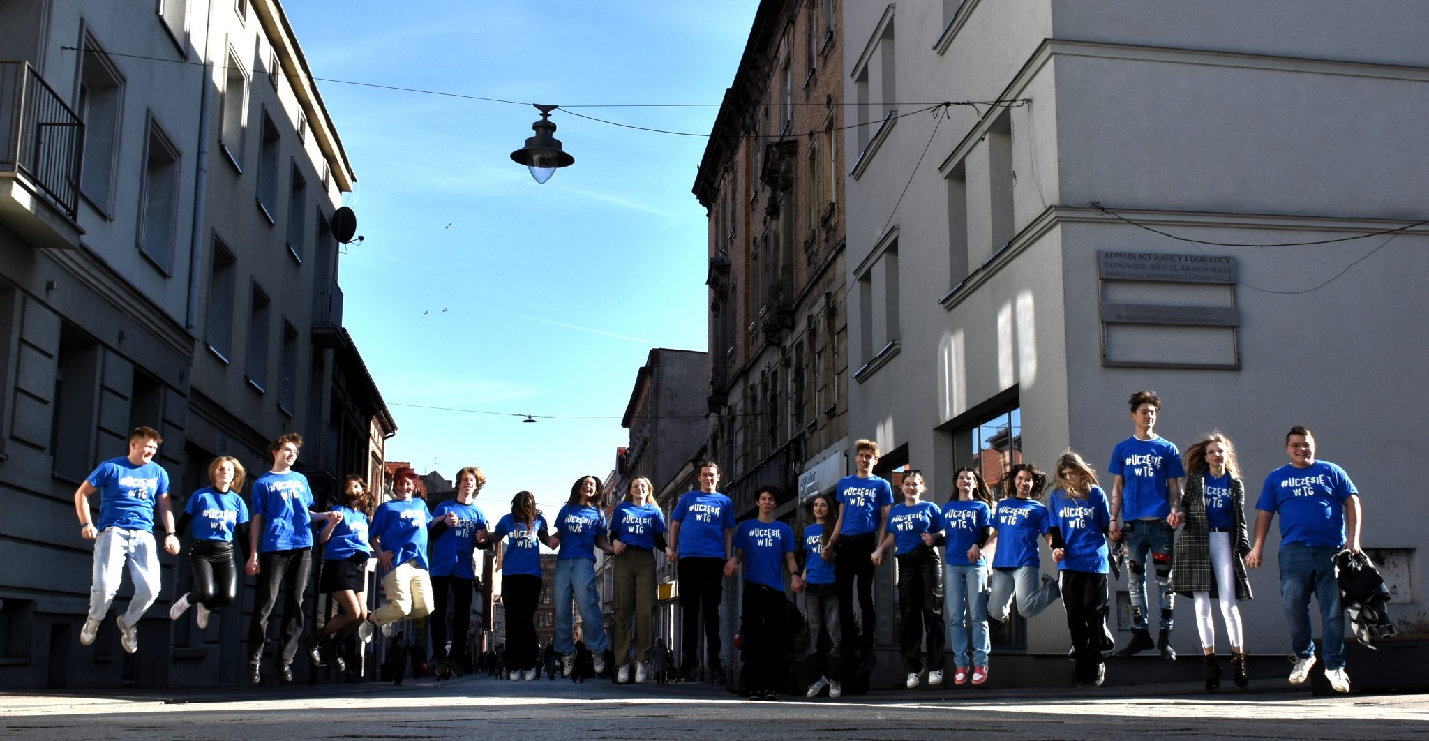 Grupa młodzieży w niebieskich koszulkach.
