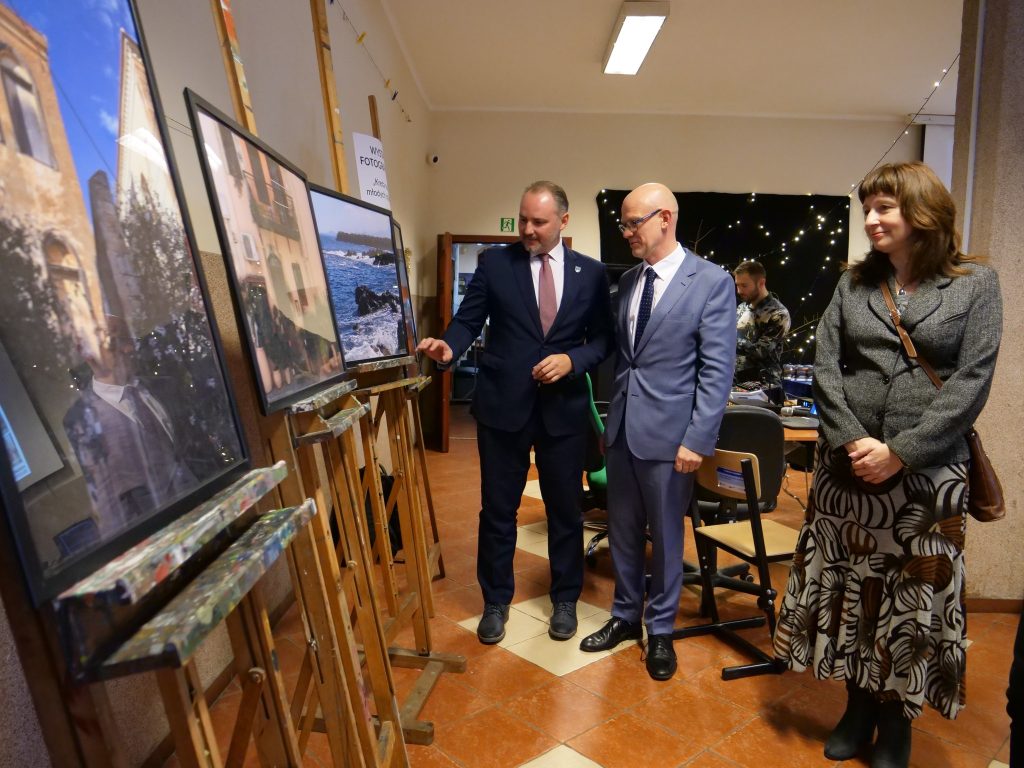 dwóch mężczyzn w garniturze i kobieta stoją w pomieszczeniu i oglądają obrazy