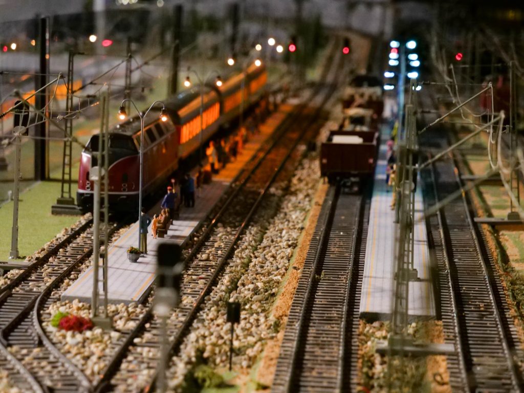 makieta przestawiająca tory, na nich pociągi, w tle kolorowe światełka