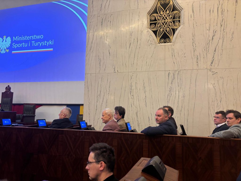 sala posiedzeń sejmowych, na pierwszym planie widać uczestników obrad, zwróceni w stronę mównicy w tle ściana oraz fragment ekranu multimedialnego z wyświetlaną prezentacją